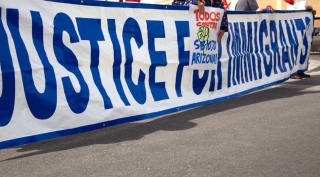 Immigration protest banner advocating for justice and fair treatment of immigrants in Arizona.
