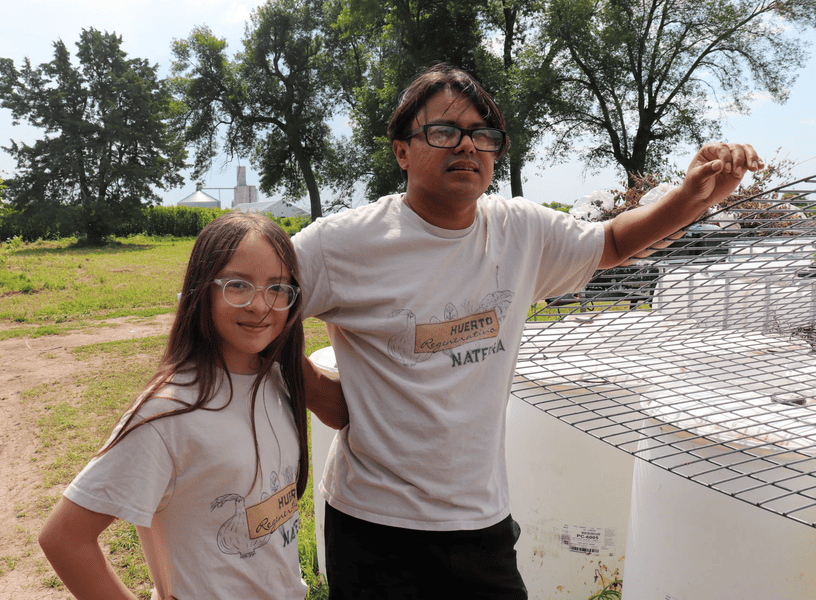 Immigrant farmers working on sustainable farm project outdoors.