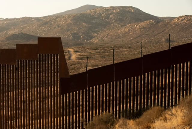 Border wall along the southern border with mountains in the background.