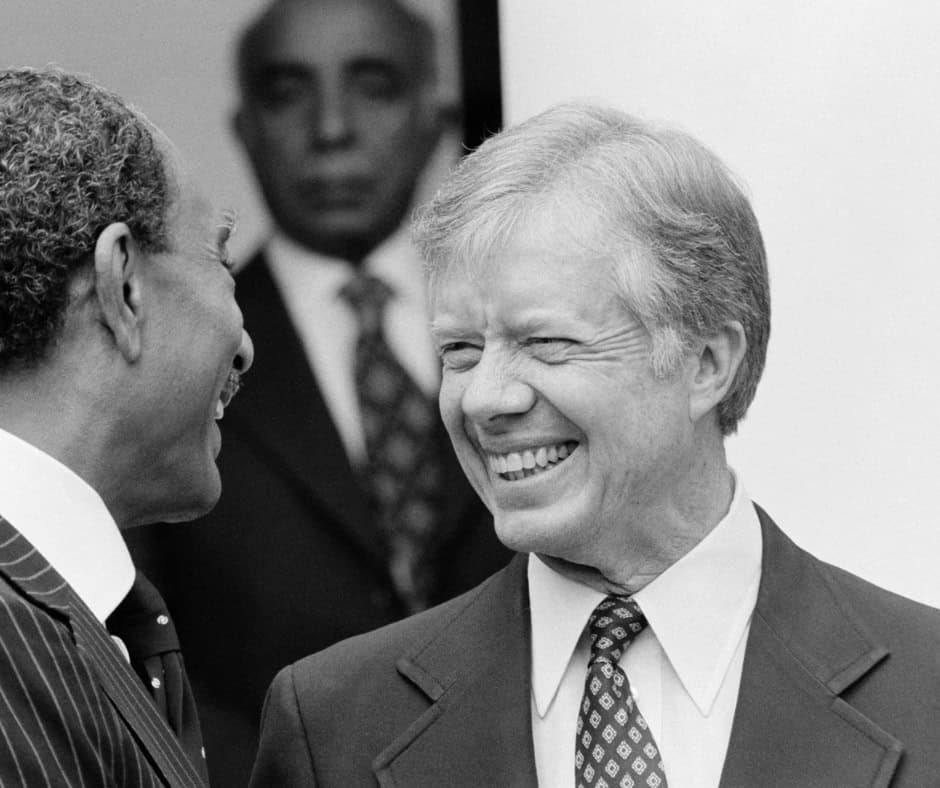 President Jimmy Carter smiling during a public event, highlighting his legacy as a defender of democ.