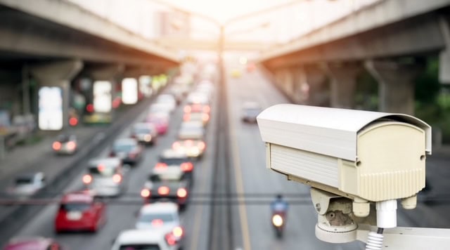 CCTV camera monitoring city traffic for facial recognition and security.