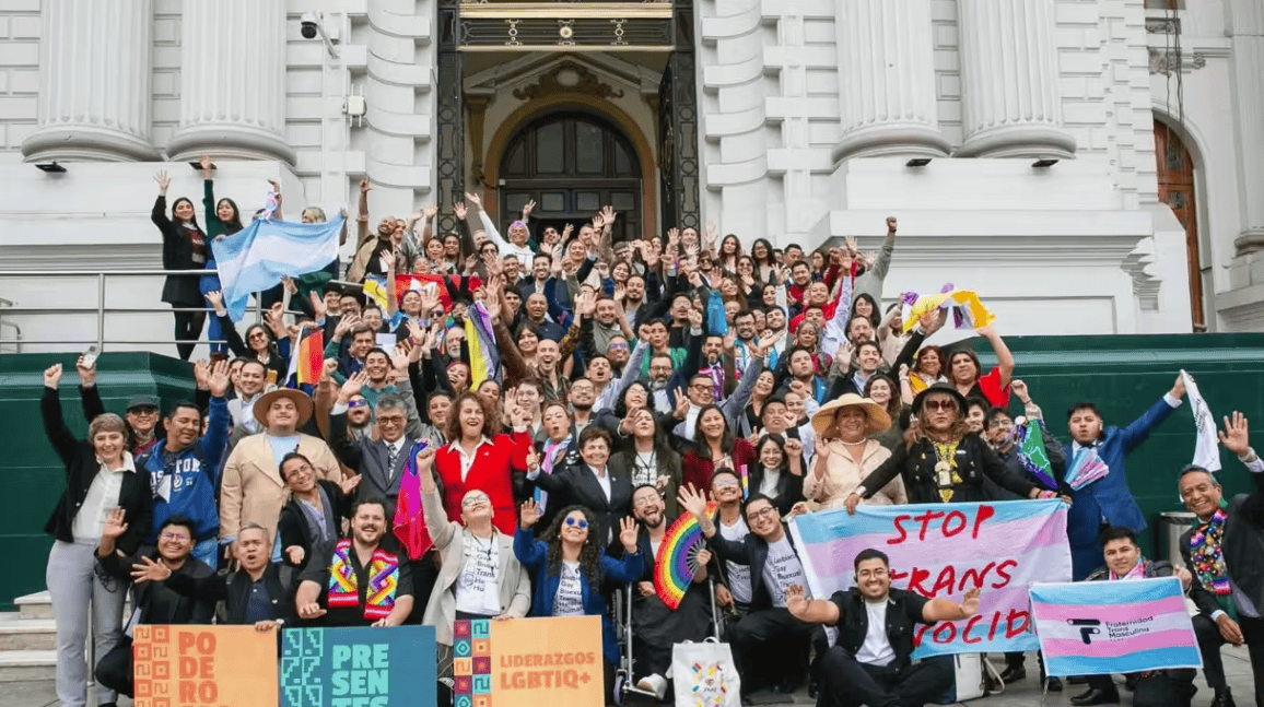 Protesters rallying for LGBTQ+ rights outside a historic government building.
