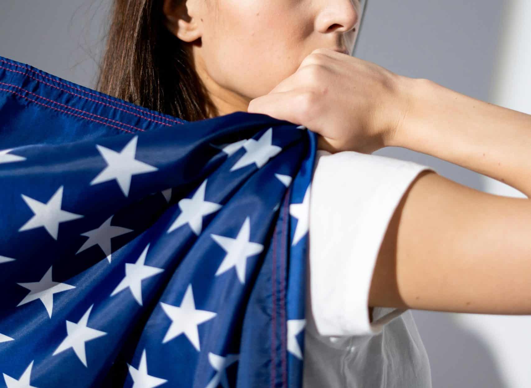 A patriotic woman poses with the American flag, symbolizing national pride.