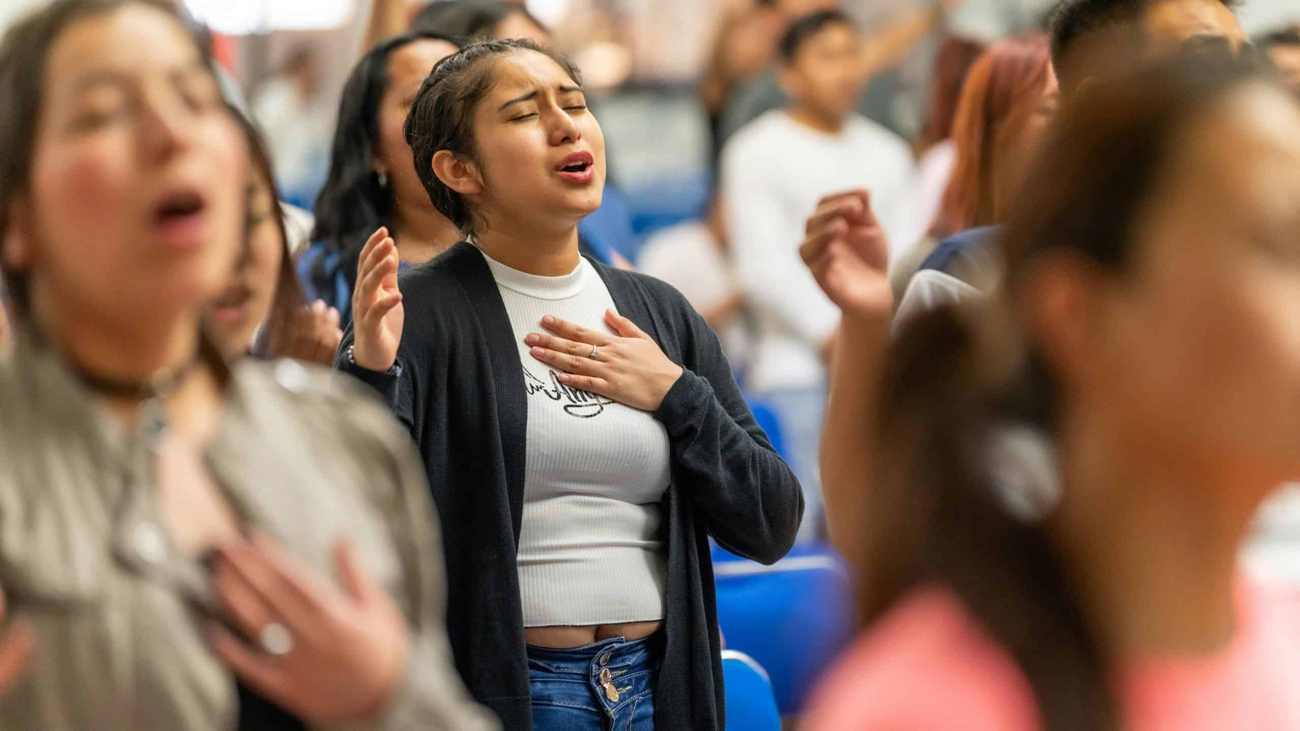 Latino individuals participating in a community prayer or gathering.