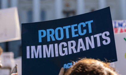 Pro-immigrant protest sign with 'Protect Immigrants' message.