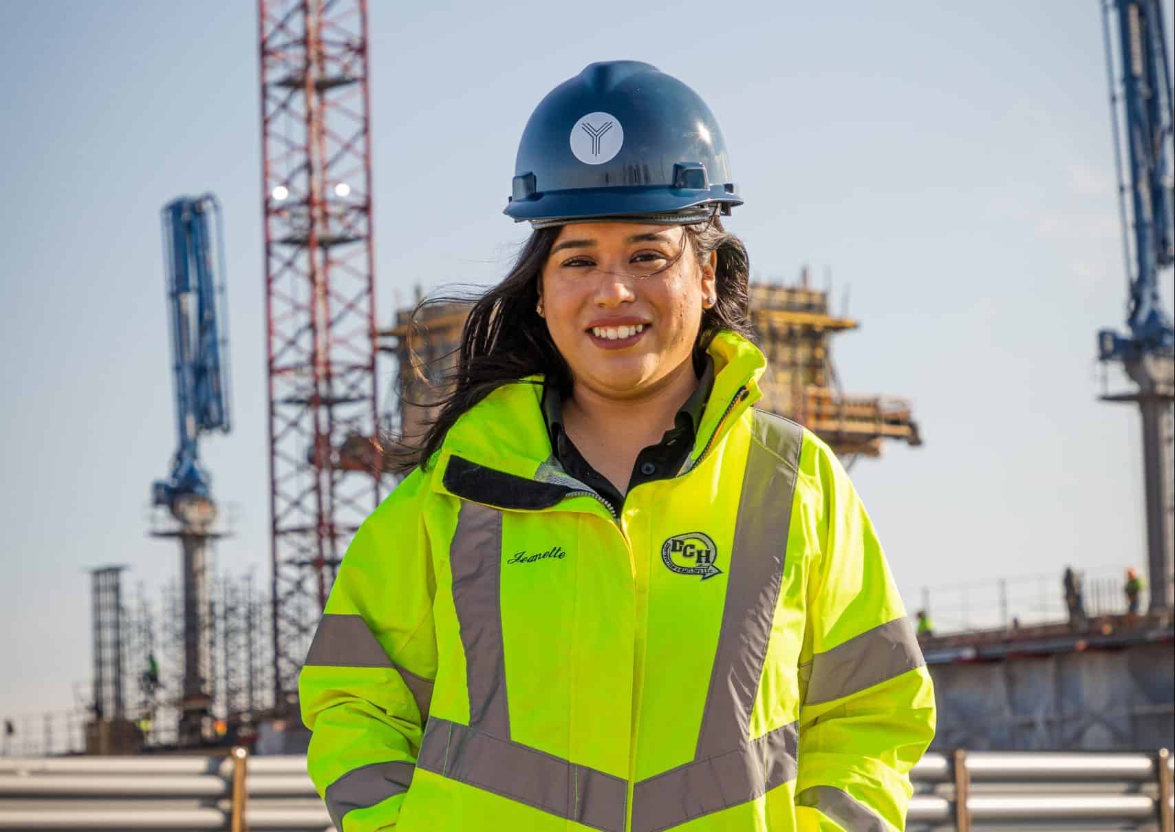 Female construction engineer in safety gear at a construction site.