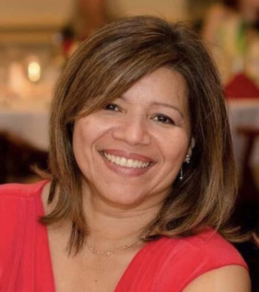 Seila Mosquera-Bruno smiling, wearing a red top, in a professional setting.