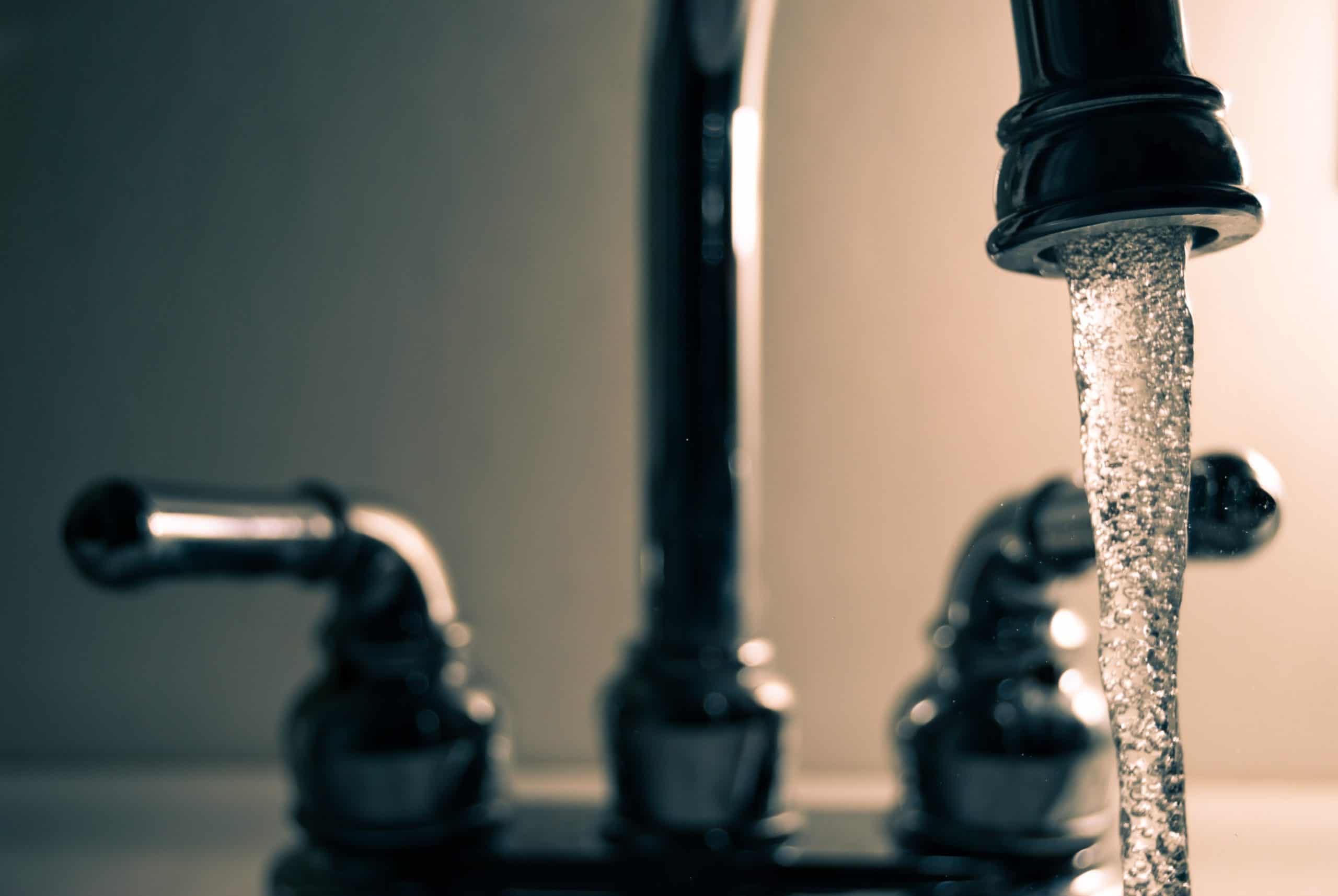 Tap water flowing from a faucet, highlighting concerns about lead contamination in municipal drinkin.