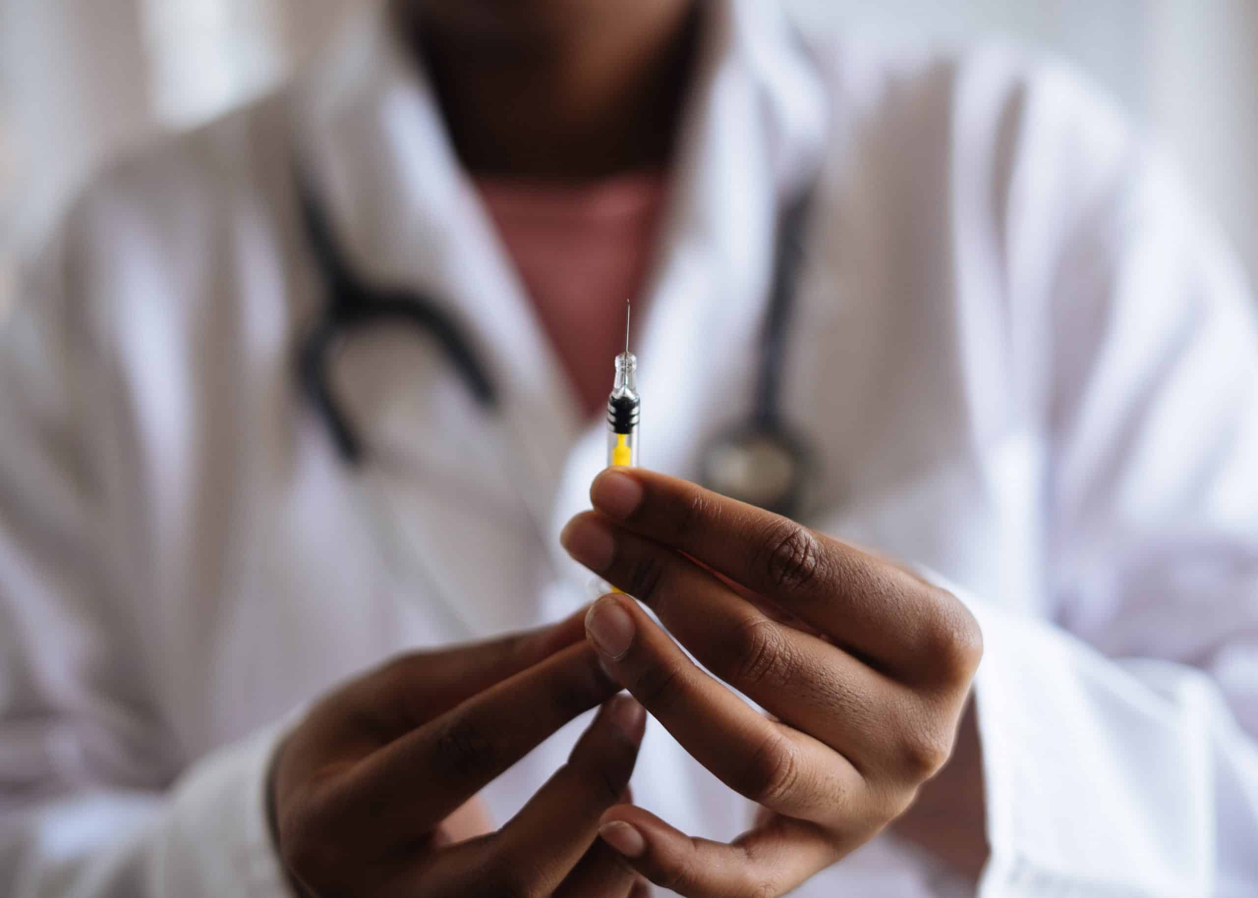 COVID-19 vaccine being prepared by healthcare professional in a clinical setting.