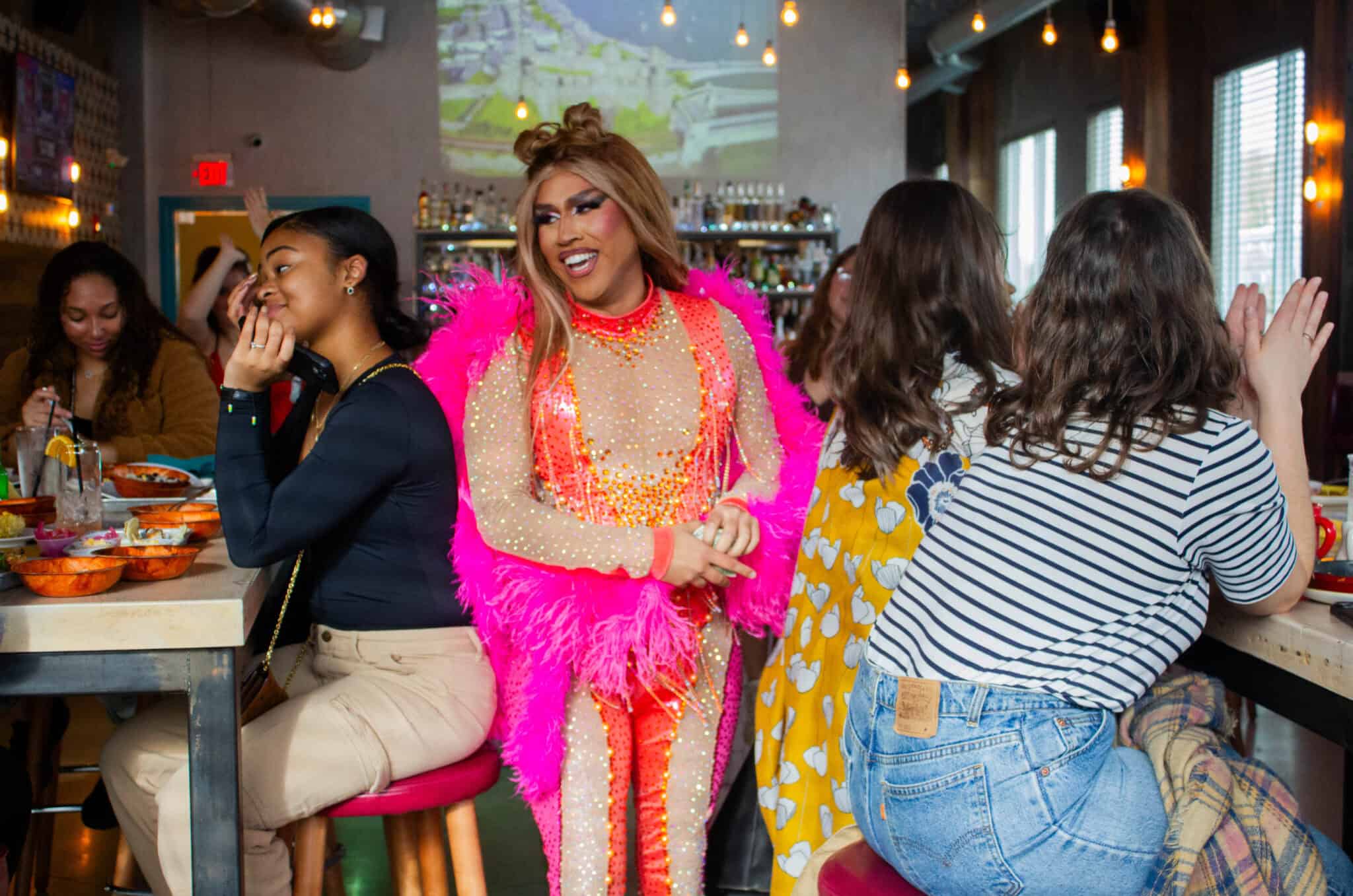 Latino drag performer in vibrant pink costume at Boston’s Latine Drag Community event.