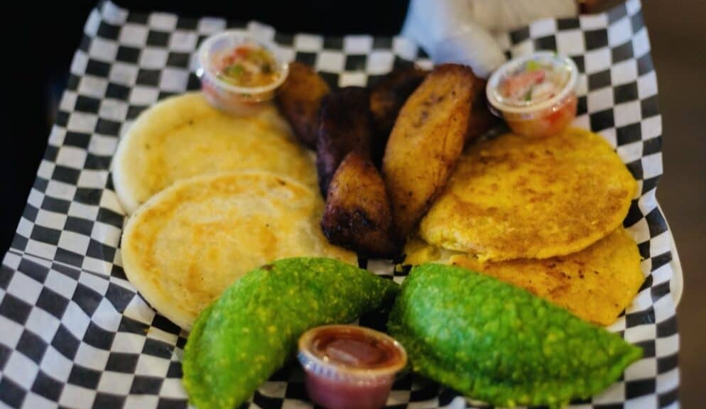 Fresh Colombian Sazón De Washington with fried plantains and dipping sauces, showcasing authentic La.
