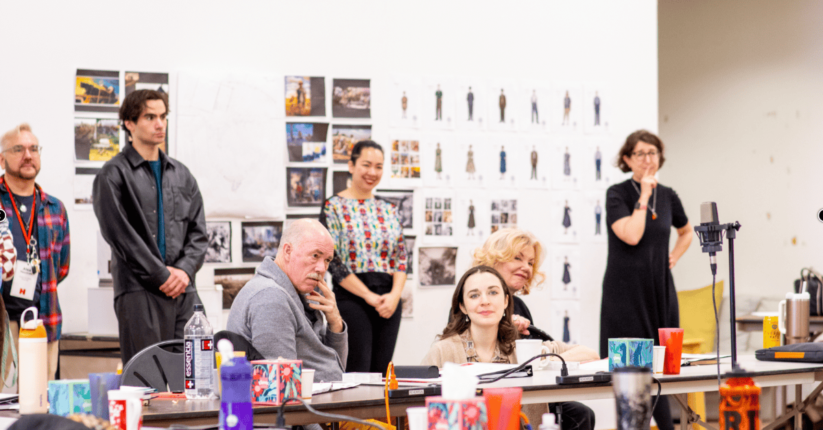 An image of actors and director during a rehearsal for "All My Sons," exploring themes of the Americ.