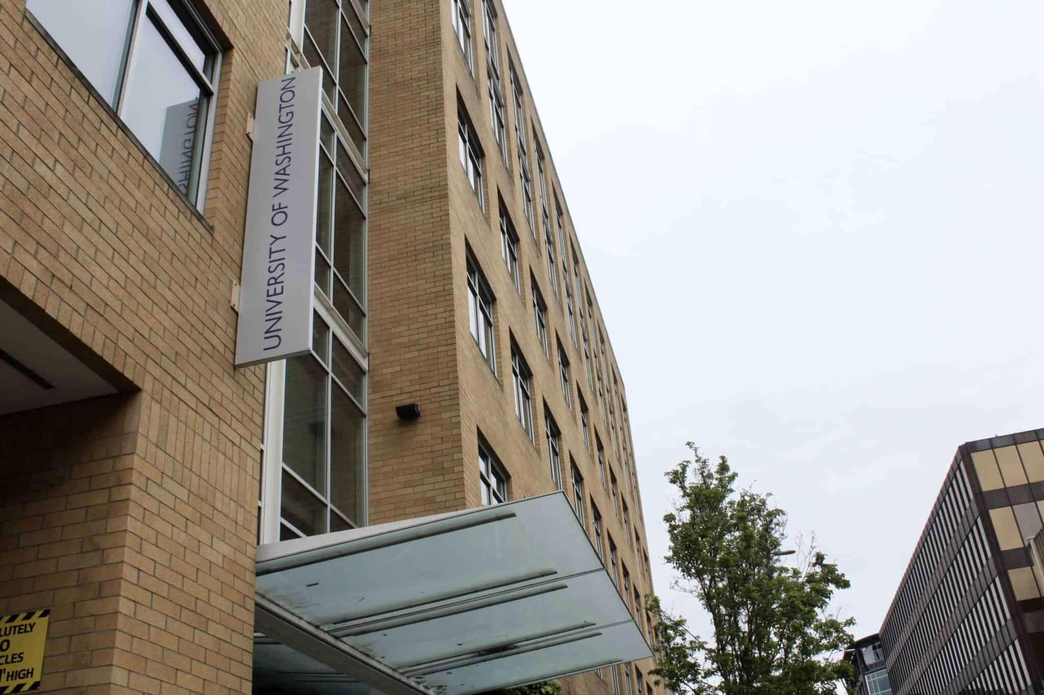 A woman walking past the University of Washington building in Seattle.