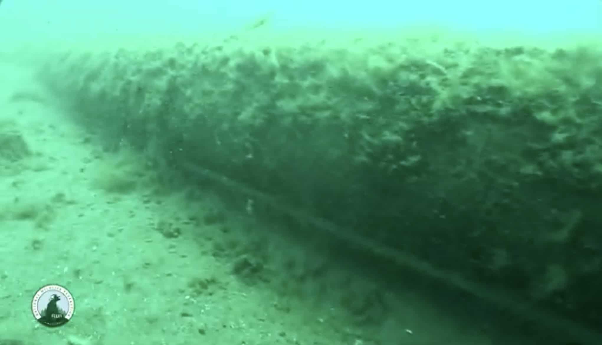 Underwater view of a submerged tunnel structure near the seabed.
