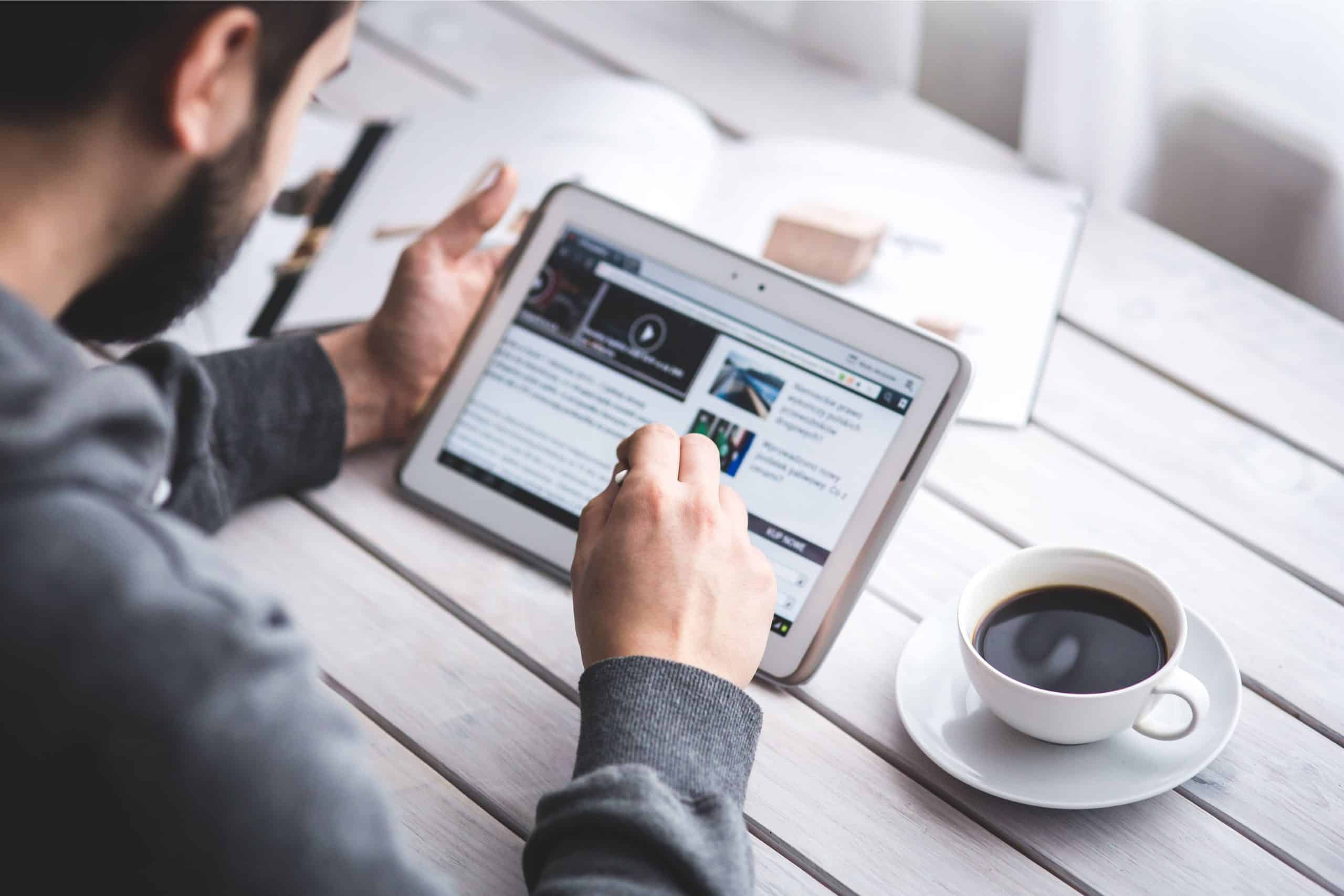 Accessible digital news consumption on a tablet with coffee, emphasizing solutions journalism and de.