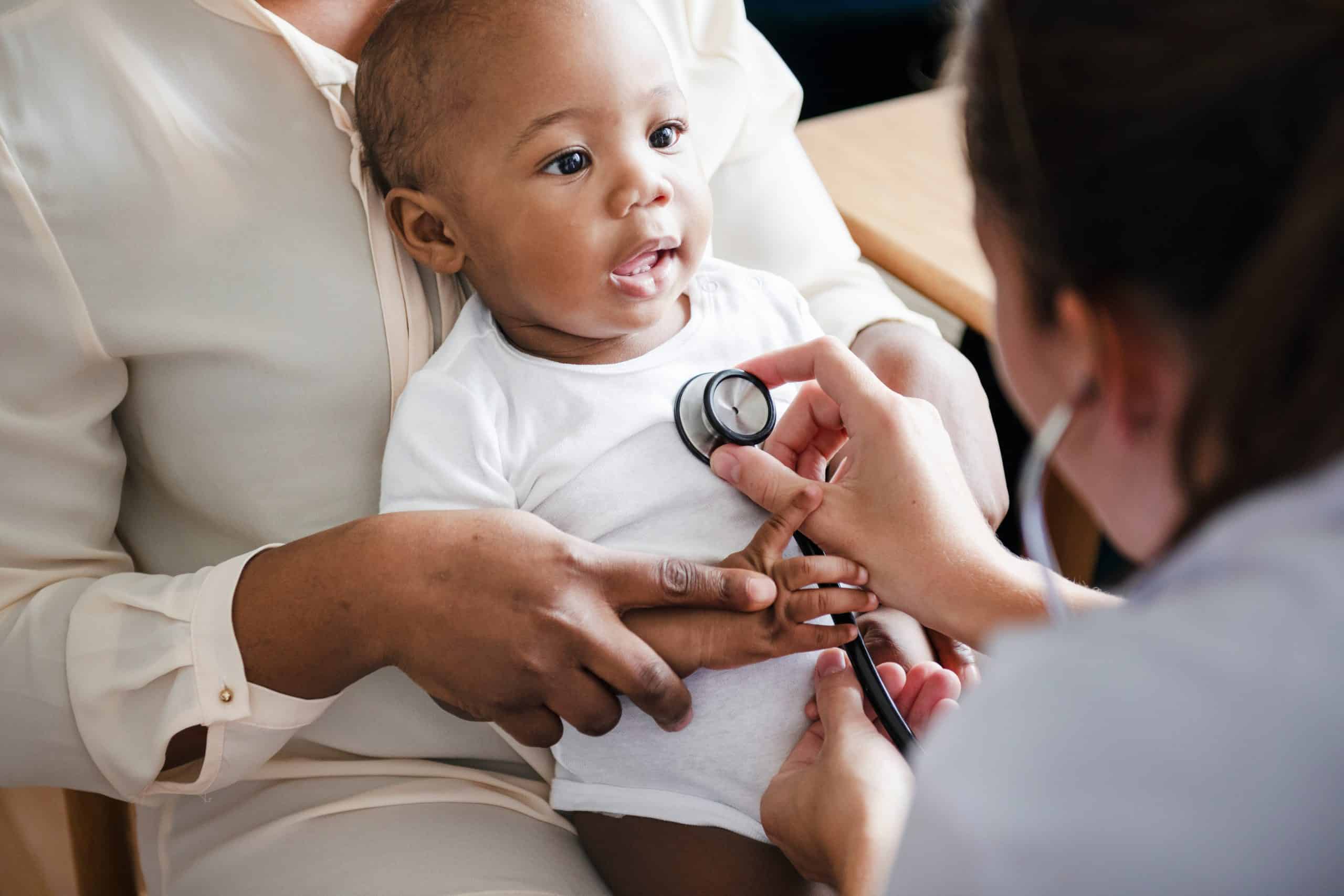 Uninsured child receiving medical checkup from healthcare professional in a clinic setting.
