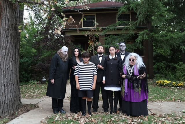 The Addams Family characters in front of a house during Chicago event.