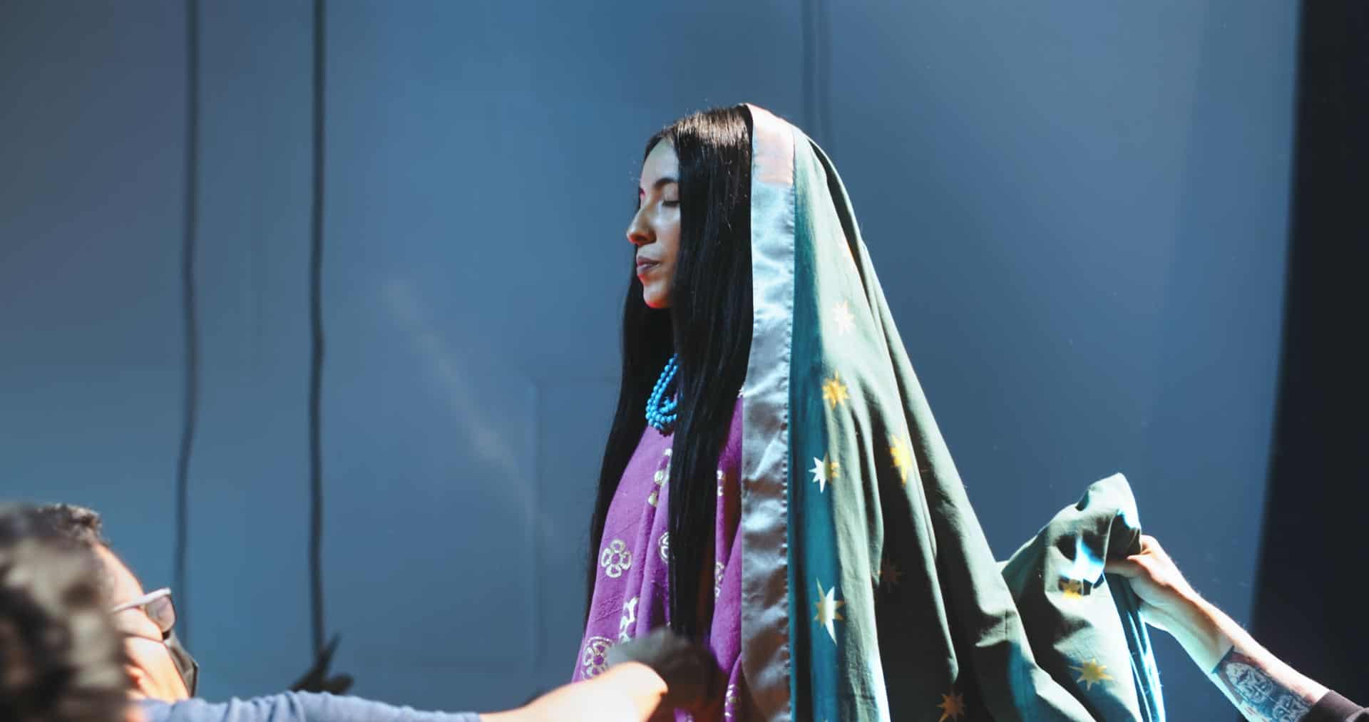 Latina woman in traditional dress at cultural event.