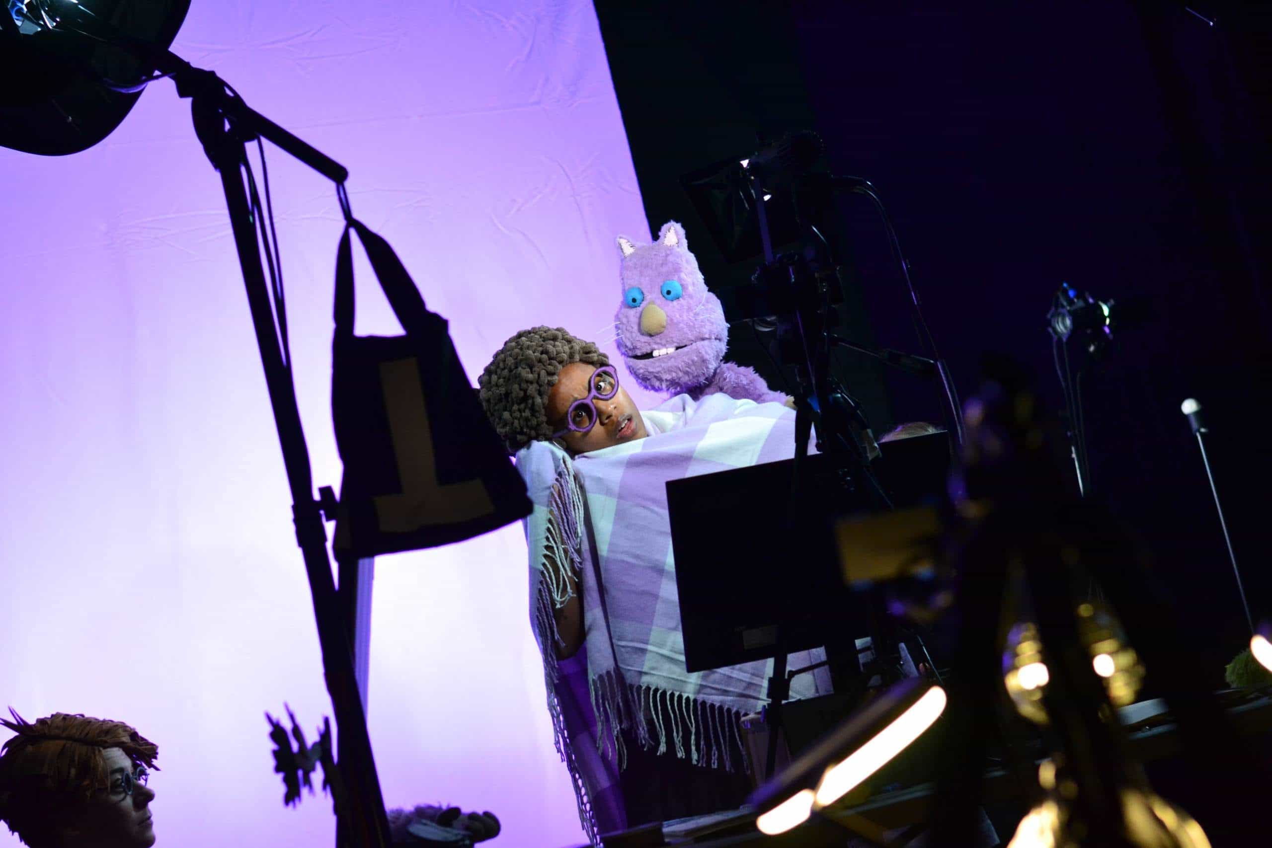 Puppeteer with puppet performing on stage during a theatrical show in Minnesota.