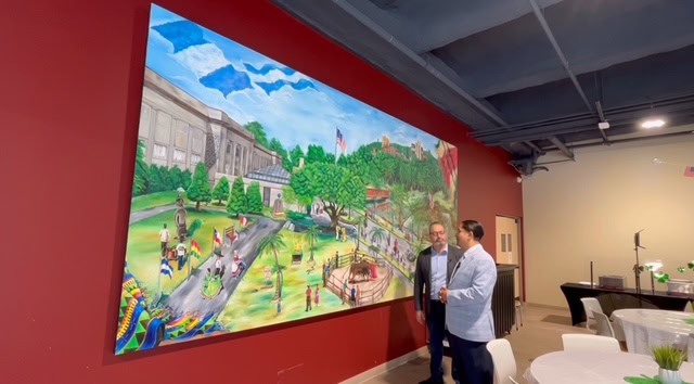 A colorful mural depicting a vibrant community park scene with people enjoying outdoor activities.