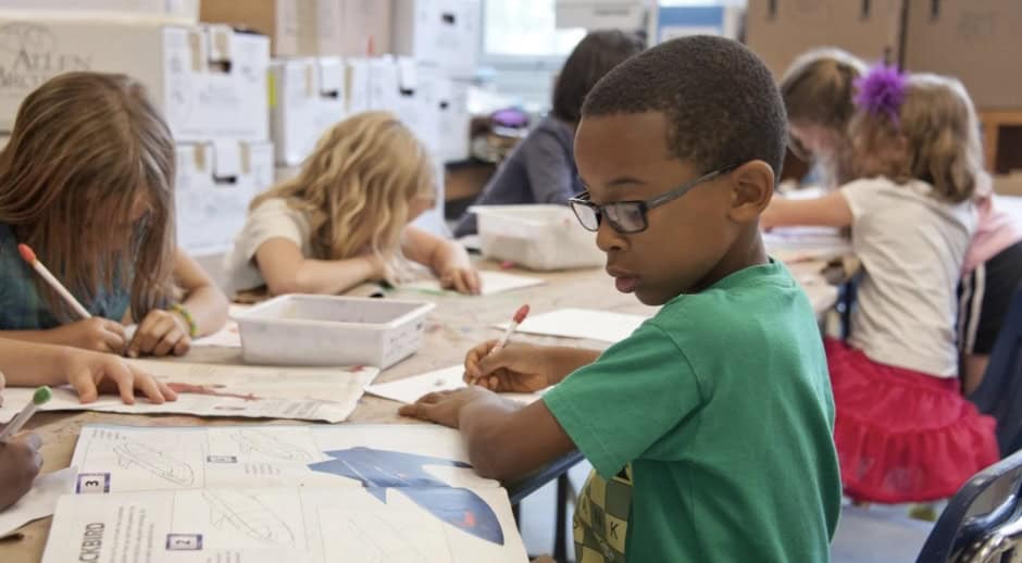 Multilingual students in a classroom working on educational activities.