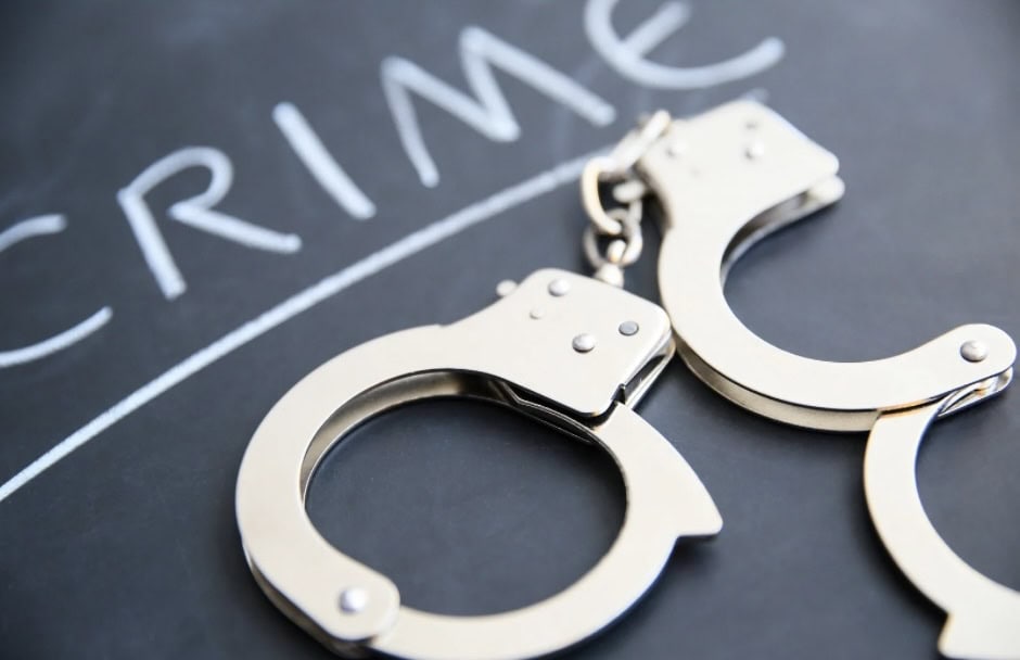 Handcuffs on a chalkboard with the word "CRIME" written above, symbolizing crime and justice issues.